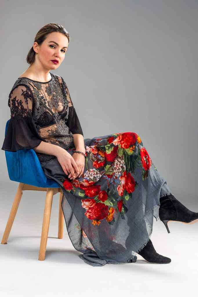 Fashion model seated in a sheer black floral dress during an editorial studio photoshoot in Mississauga
