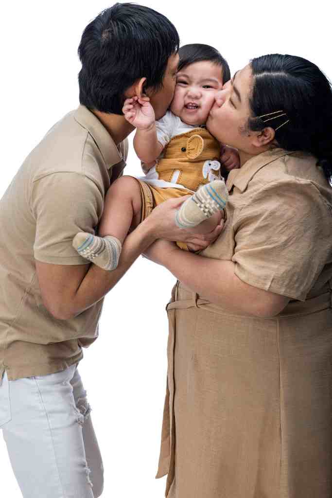 Parents kissing their baby during a family portrait photography session in Mississauga